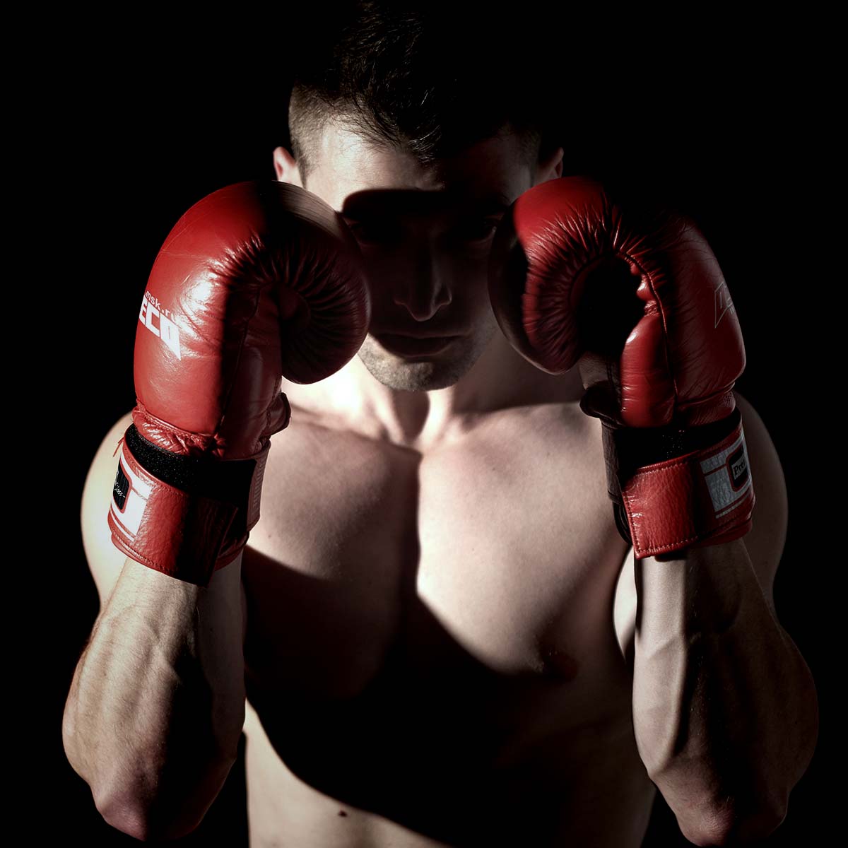 Ein Mann in Boxhandschuhen zeigt stolz seine Pose für ein Foto.