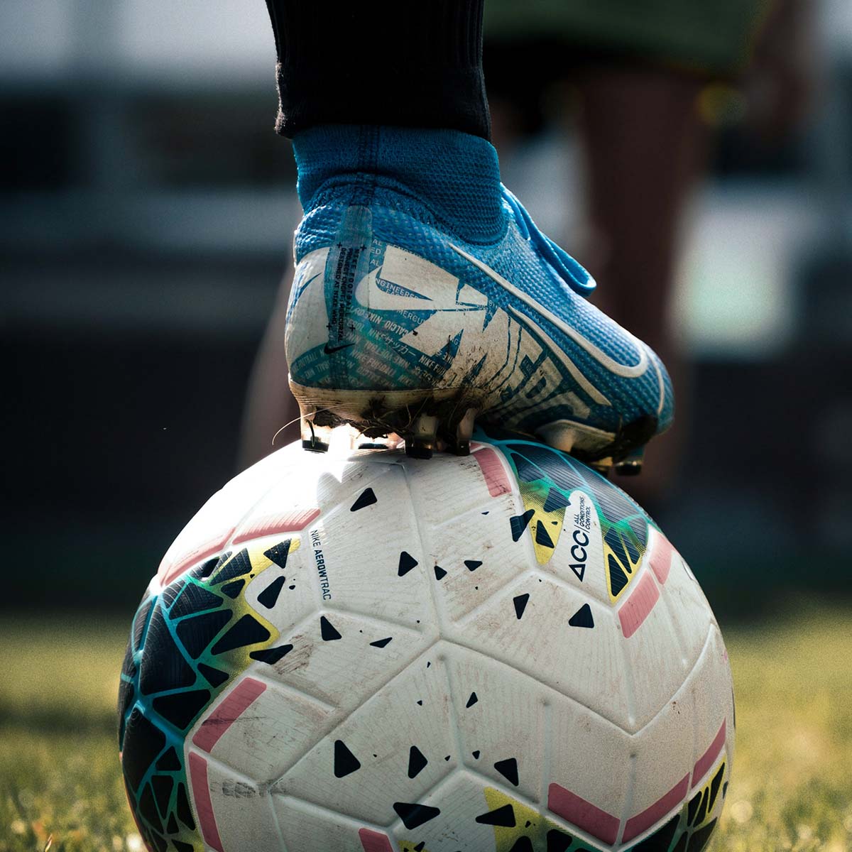 Ein Fußball, auf dem ein Fuß steht, bereit für den nächsten Schuss.