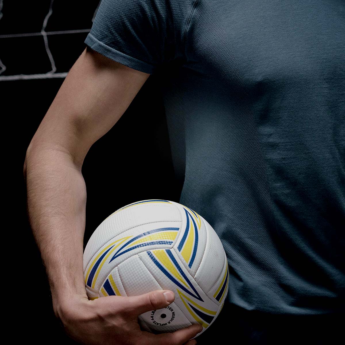 Eine Frau präsentiert stolz einen Volleyball, bereit zum Spielen.